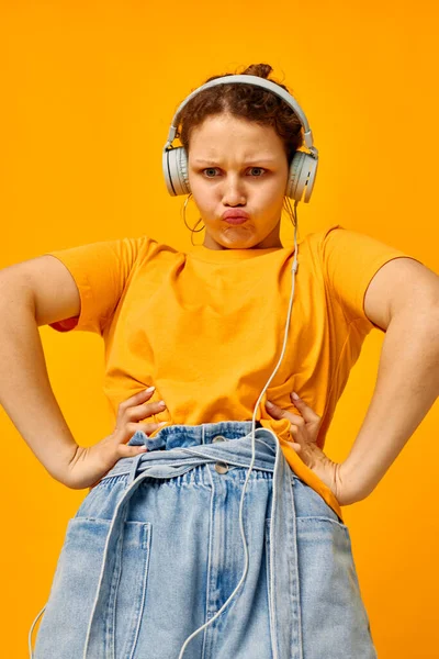 Bonita chica amarillo camiseta auriculares entretenimiento música divertido aislado fondos inalterados — Foto de Stock