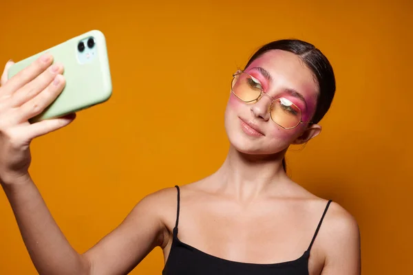 Bella donna sorriso luminoso rosa trucco emozioni cosmetici smartphone selfie isolato sfondo inalterato — Foto Stock