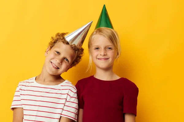 Diversión de vacaciones para niños pequeños con gorras en su cabeza fondo amarillo —  Fotos de Stock