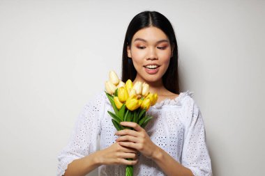 Beyaz gömlekli güzel bir esmer. Çiçekler bahar mevsimi. Yaşam tarzını değiştirmemiş.