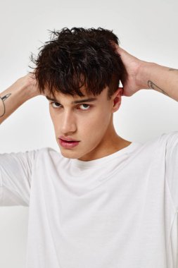 Yakışıklı adam kolunda modern gençlik tarzı beyaz tişört dövmesi var. Arka planda değişiklik yok.