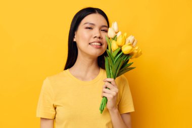 Bir buket sarı çiçekli çekici Asyalı kadın. Romantik stüdyo modeli değiştirilmemiş.