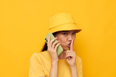 Çekici genç Asyalı kadın elinde bir telefonla yaşam tarzı teknolojisi modelini değiştiriyor.