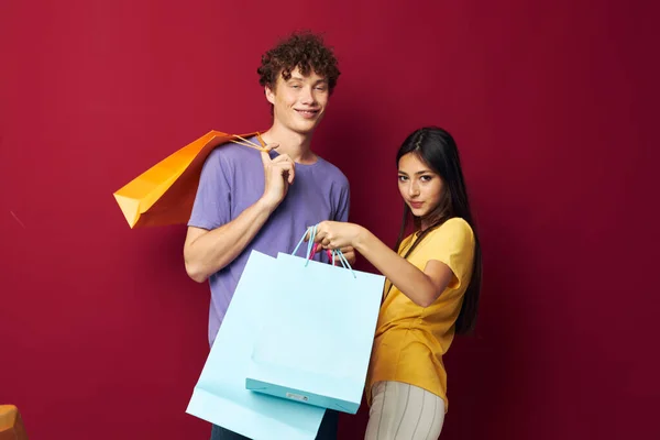 Έφηβοι πολύχρωμες τσάντες ψώνια διασκέδαση κόκκινο φόντο αναλλοίωτη — Φωτογραφία Αρχείου