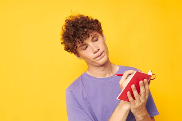 Chlap s červenými kudrnaté vlasy poznámkový blok s perem učení emoce žluté pozadí beze změny — Stock fotografie