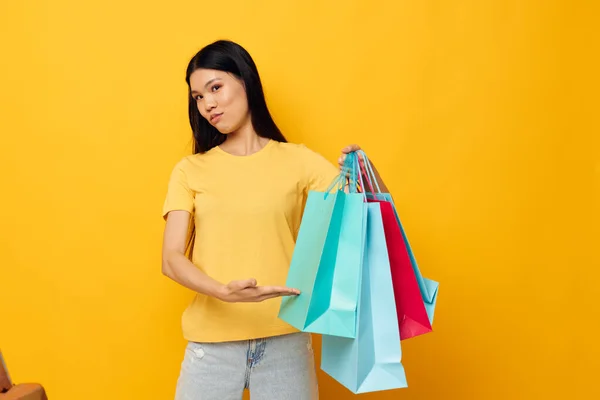 Vrouw met aziatische verschijning met pakketten in handen winkelen geïsoleerde achtergrond ongewijzigd — Stockfoto