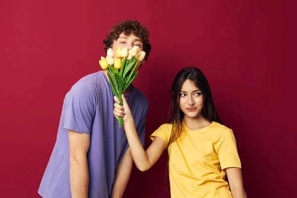 Jong jongen en meisje boeket van bloemen cadeau romantiek geïsoleerde achtergrond ongewijzigd — Stockfoto