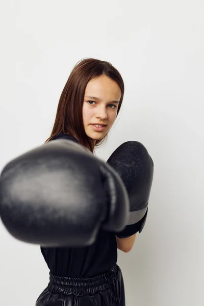 Young beautiful woman in boxing gloves punch in black pants and a T-shirt Lifestyle unaltered — Stockfoto