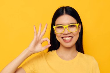 Sarı tişörtlü güzel esmer gözlüklü, modadan soyutlanmış arka plan değiştirilmemiş.