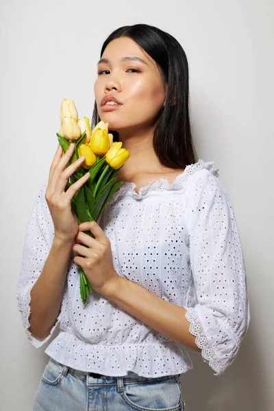 Morena bonita em uma camisa branca flores primavera posando fundo isolado inalterado — Fotografia de Stock