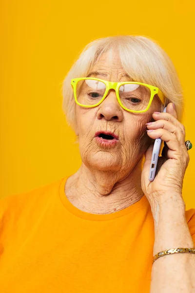 Улыбающаяся пожилая женщина в повседневной связи футболки по телефону эмоции крупным планом — стоковое фото
