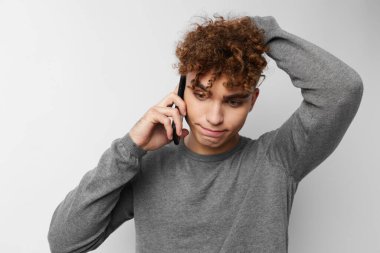 Yakışıklı genç adam telefonda konuşuyor. Duygularını dışa vuruyor.