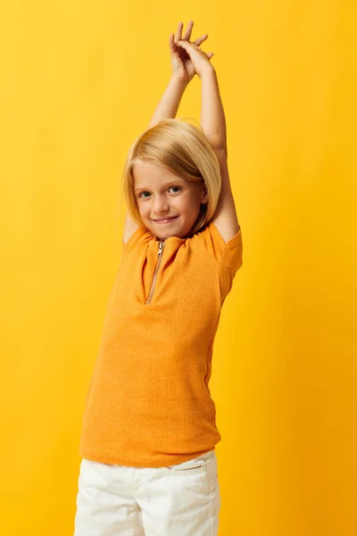 Criança menina em um amarelo t-shirt sorriso posando estúdio isolado fundo inalterado — Fotografia de Stock