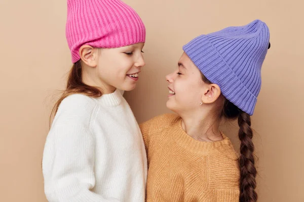 Duas meninas engraçadas abraçando posando chapéus coloridos — Fotografia de Stock