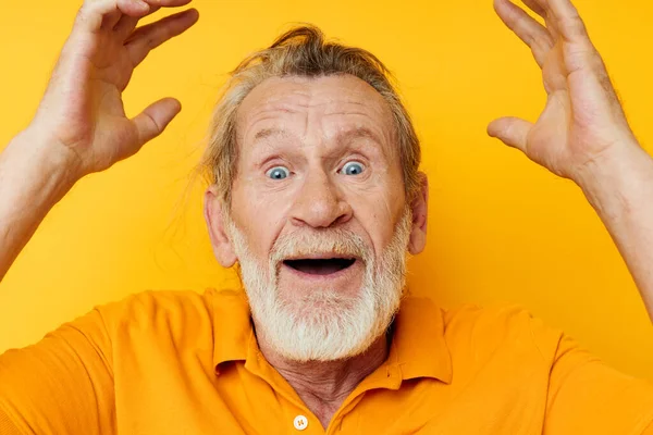 Homme âgé aux cheveux gris avec une barbe grise émotion gestes mains fond jaune — Photo