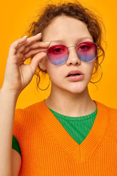 明るい女性オレンジのスウェットシャツサングラス多色眼鏡供給クリップビュー変更なし — ストック写真