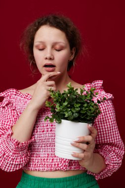 Elinde bir saksı tutan bir kadın. Hiç değiştirilmemiş pozlar veriyor.