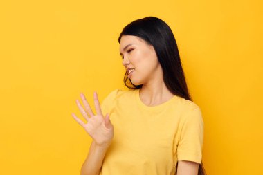 Sarı tişörtlü güzel esmer, kafasından memnun olmayan stüdyo modelini tutuyor.