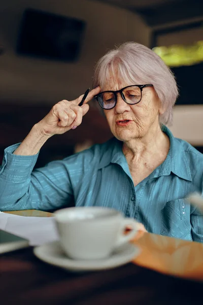 Idoso mulher documentos folha de trabalho de papel e caneta aposentado mulher conversando inalterado — Fotografia de Stock