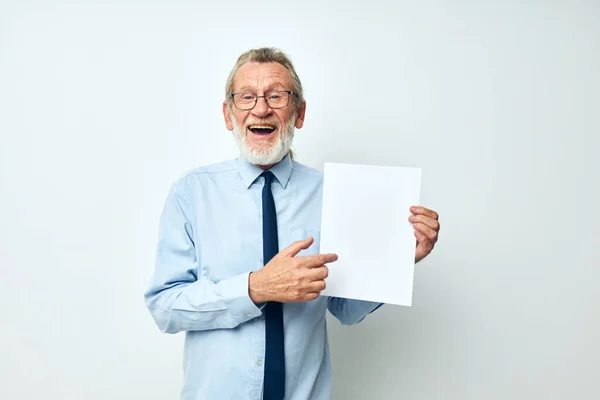 Portrait of happy senior man holding documents with a sheet of paper light background