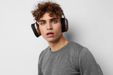 Gri süveter kulaklıklı yakışıklı adam. Moda arkaplanı.