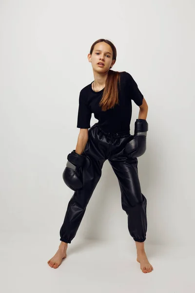 Молодая женщина боксирует черные перчатки, позируя спортивный стиль жизни неизменным — стоковое фото