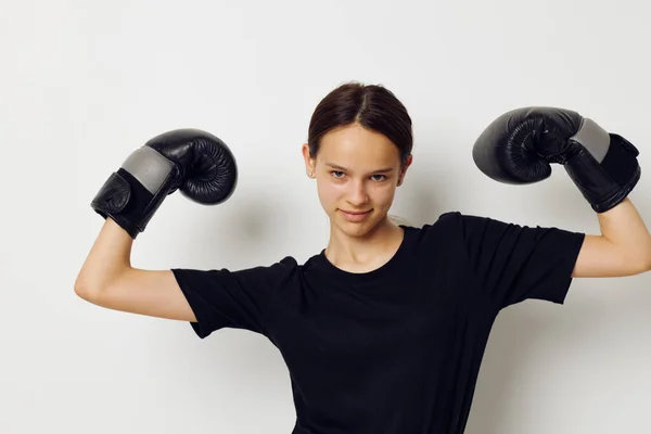 身穿黑裤子拳击手套和T恤健身训练的女运动员 — 图库照片