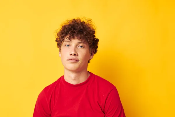 Chico con rojo rizado pelo emociones rojo camiseta sombrero estudio amarillo fondo inalterado — Foto de Stock