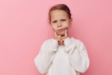 Mutlu gülümseyen çocuk portresi beyaz süveter, izole edilmiş eğlenceli bir arka plan.