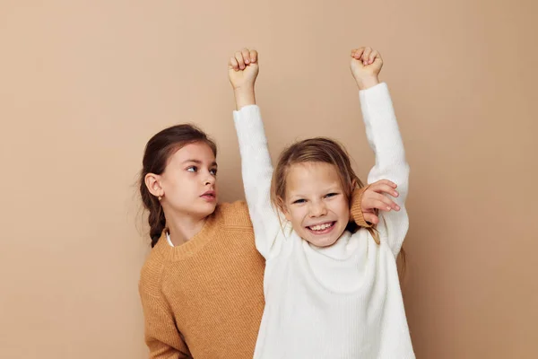 Twee leuke kleine meisjes knuffel vriendschap levensstijl beige achtergrond — Stockfoto