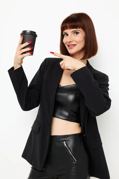 Portrait of a woman in a black suit a mug with a drink charm isolated background — Stockfoto