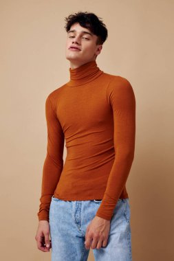 Yakışıklı adam kahverengi balıkçı yaka. Moda arkaplan pozu veriyor.