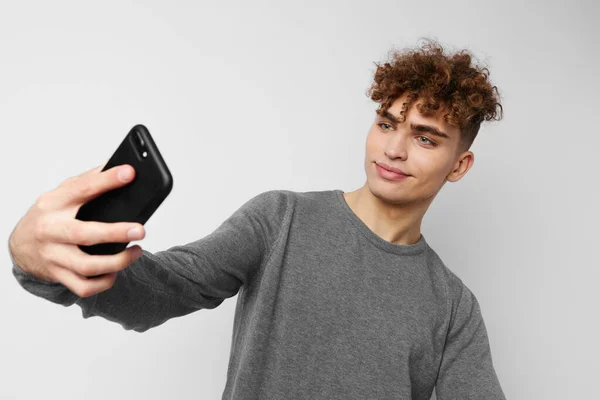 Tipo con estilo con un teléfono en la comunicación de la mano aislado fondo — Foto de Stock