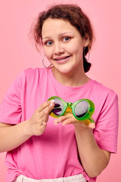 Yeşil gözlüklü genç bir kadın elleriyle süsleme hareketi yapıyor Stüdyo Modeli — Stok fotoğraf