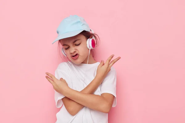 Portrait of happy smiling child girl listening to music on headphones isolated background — Foto Stock