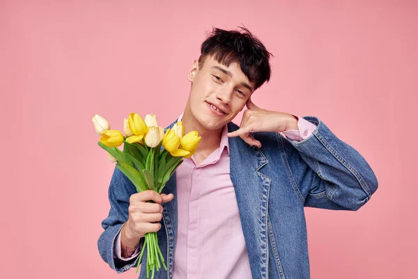 Фото романтичного молодого хлопця в джинсовій куртці з букетом квітів подарункова романтика Стиль життя незмінний — стокове фото