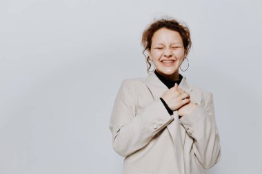 Güzel bir kadın, klasik bir takım elbiseyle, duyguları sarı arka planda pozlandırıyor.