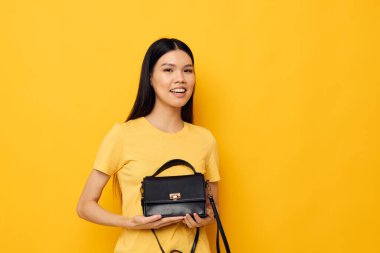 Güzel esmer ve elinde siyah bir kadın çantası var. Stüdyo modeli değiştirilmemiş.