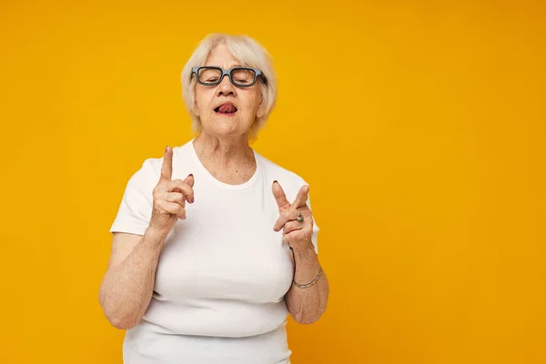 Fotografie důchodce stará dáma v bílém tričku nosí brýle izolované pozadí — Stock fotografie