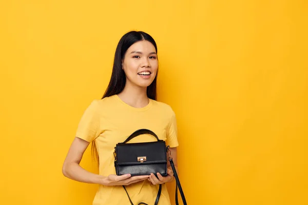 Vacker brunett med en svart kvinna väska i händerna studio modell oförändrad — Stockfoto
