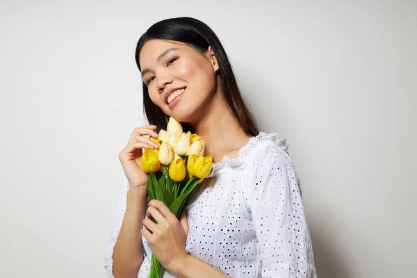 꽃 다발을 들고 있는 아시아인아름다운 젊은 여성의 초상화 변경되지 않은 스튜디오 모델 미소를 클로즈업 — 스톡 사진