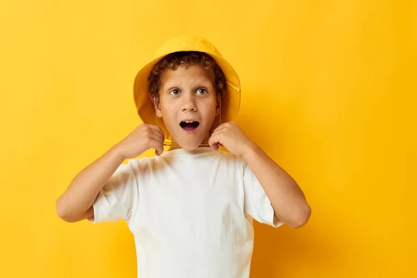 Boy in white t-shirt yellow hat posing emotions — Stockfoto