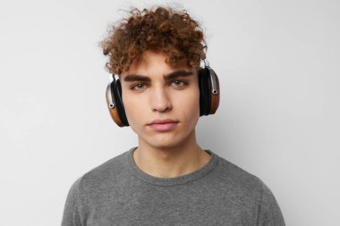 Gri süveter kulaklıklı yakışıklı adam. Moda arkaplanı.