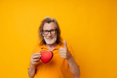 Sarı gözlüklü yaşlı bir adam, gri sakallı, kırmızı kalpli, tek renkli.