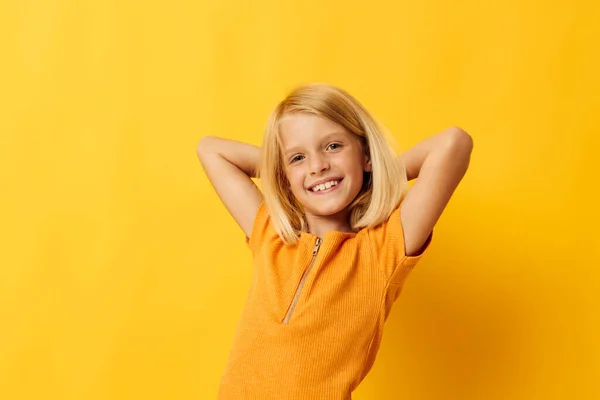 Портрет маленькой девочки улыбаются жесты руки, представляя случайную носить весело изолированный фон без изменений — стоковое фото