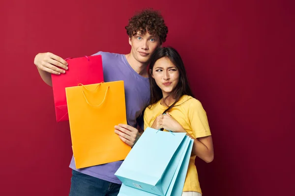 Teenagers in colorful T-shirts with bags Shopping isolated background unaltered — Stock Photo, Image
