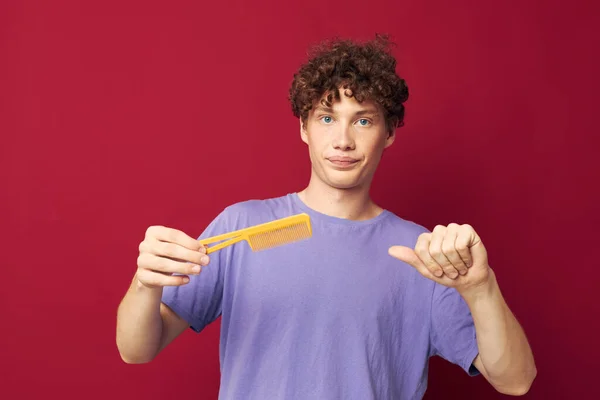 Chlap s červenými kudrnatými vlasy ve fialových tričkách s hřebenem izolované pozadí — Stock fotografie