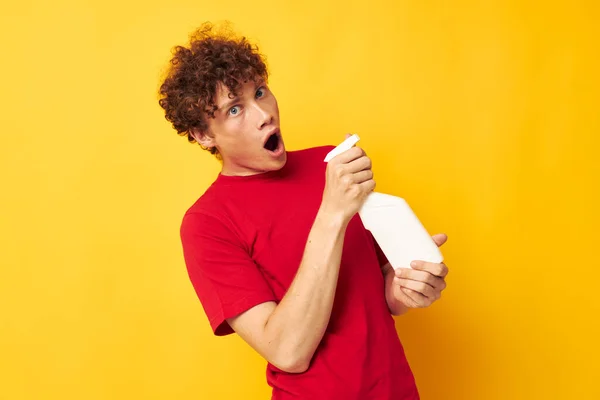 Retrato de um jovem homem encaracolado detergentes home care posando fundo isolado inalterado — Fotografia de Stock