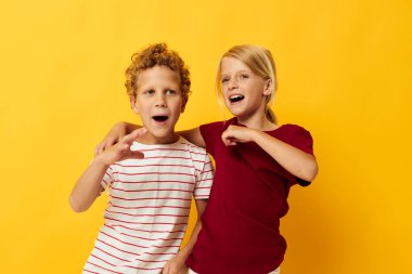 İki neşeli çocuk, gündelik kıyafetlerini giyer, oyun oynarlar, birlikte eğlenirler.