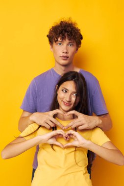 Renkli tişörtler içinde sevimli genç bir çift Arkadaşlık pozu veren eğlenceli yaşam tarzı değiştirilmemiş